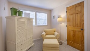Een kamer met een kast, een bank, een lamp en een houten deur.