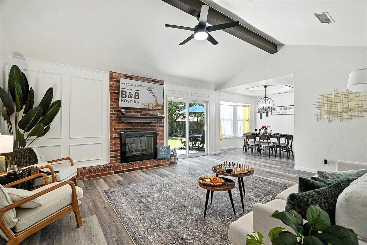 A spacious living area with a fireplace, a dining table, and a seating arrangement.