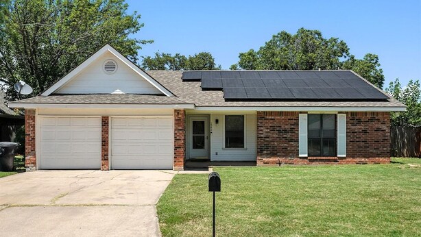 A single-story house with a garage, a covered porch, and a solar panel roof. - The Gathering Place: Near Zoo/Park & Expo Center (Abilene)
