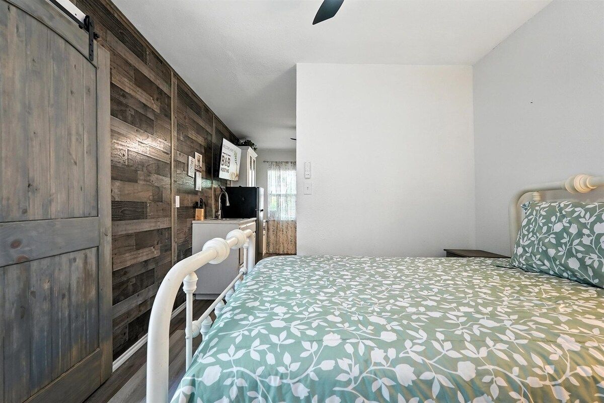 A bedroom with a bed, a wardrobe, and a television.