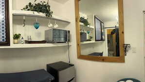 Un bagno con specchio, lavabo e toilette. Decorazioni alle pareti, tra cui un oggetto a forma di cuore e una fotografia incorniciata.