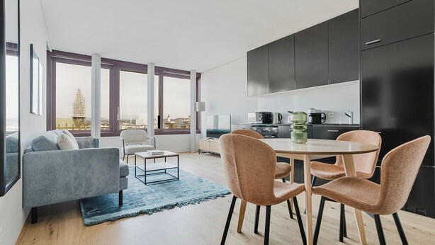 Un appartement moderne comprenant un espace de vie, un coin repas et une cuisine.