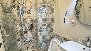 Un baño con ducha, inodoro y lavamanos.