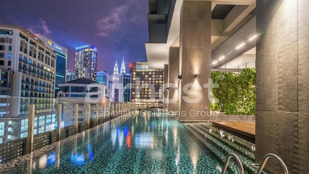 Piscina moderna de hotel con vista a la ciudad, que incluye una barrera de vidrio y una piscina reflectante.