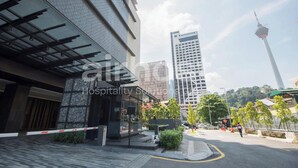 Un edificio moderno con fachada de vidrio y entrada cubierta.