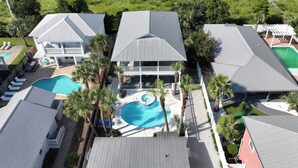 Ein großes Resort mit mehreren Gebäuden, einem zentral gelegenen Swimmingpool und umliegenden Palmen.