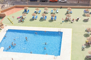 A swimming pool with people swimming and sunbathing areas with umbrellas and lounge chairs. - Luxury beachfront suite Fuengirola for 2, Fuengirola, Spain (Fuengirola)