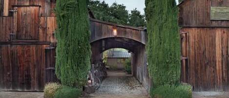 A rustic wooden bridge leading to a building with a signboard.