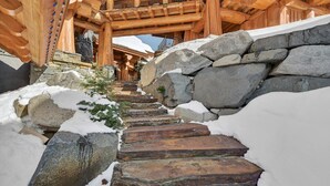 Una escalera de madera con escalones de piedra que lleva a un edificio con techo de madera.