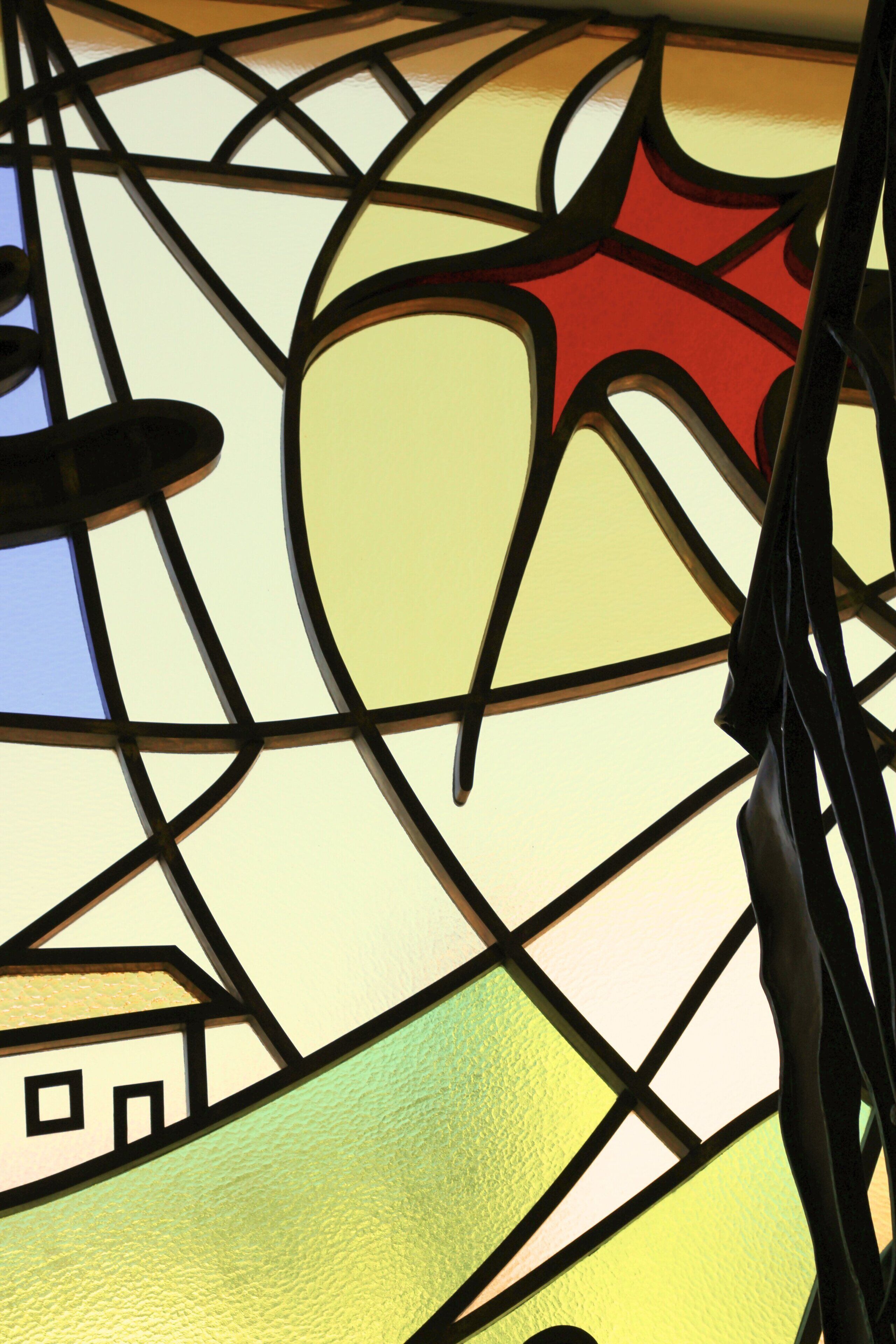 A stained glass window with geometric patterns and a central red star.