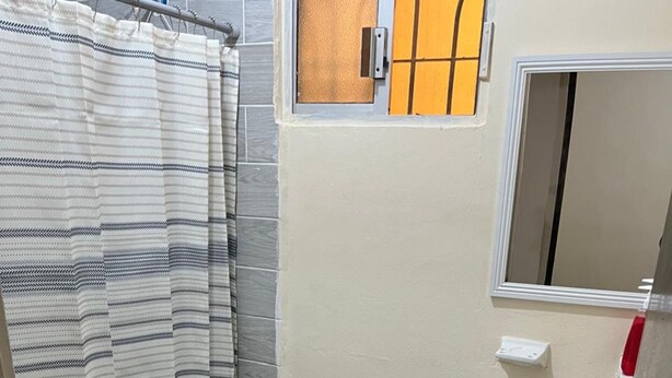 Une petite salle de bain avec des toilettes, un lavabo et un rideau de douche.