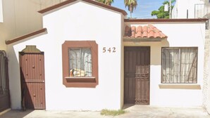 A two-story house with a number 542 on the facade, a brown door, and a window with barred glass. - Spacious, centrally located house near Laguna del Náinari (Ciudad Obregón)