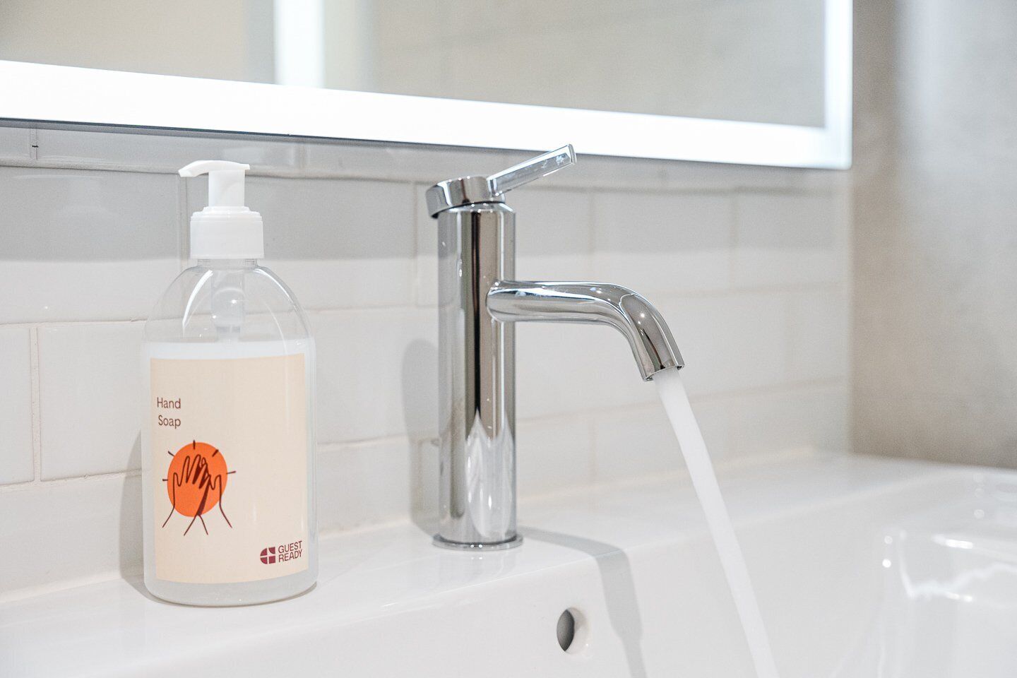 Ein Badezimmer mit Handseifenspender und Wasserhahn.