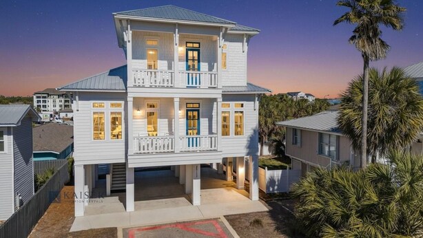 A two-story house with a balcony on the upper floor, a covered front porch, and a view of the surrounding neighborhood. - Beach Side Home, Steps from the Sand. Ocean Edge 14 New Build 2025 (Orange Beach)