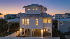 A two-story house with a balcony, multiple windows, and a porch. - Beach Side Home, Steps from the Sand. Ocean Edge 14 New Build 2025 (Orange Beach)