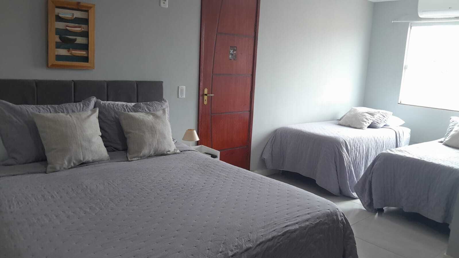 Una camera da letto con due letti, una porta in legno e una finestra.