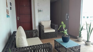 A room with wicker furniture, a blue table, and potted plants. - Canoa dos Anjos Suites (Arraial do Cabo)