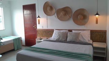 Een hotelkamer met een bed, nachtkastjes, een kledingkast en een grote deur.
