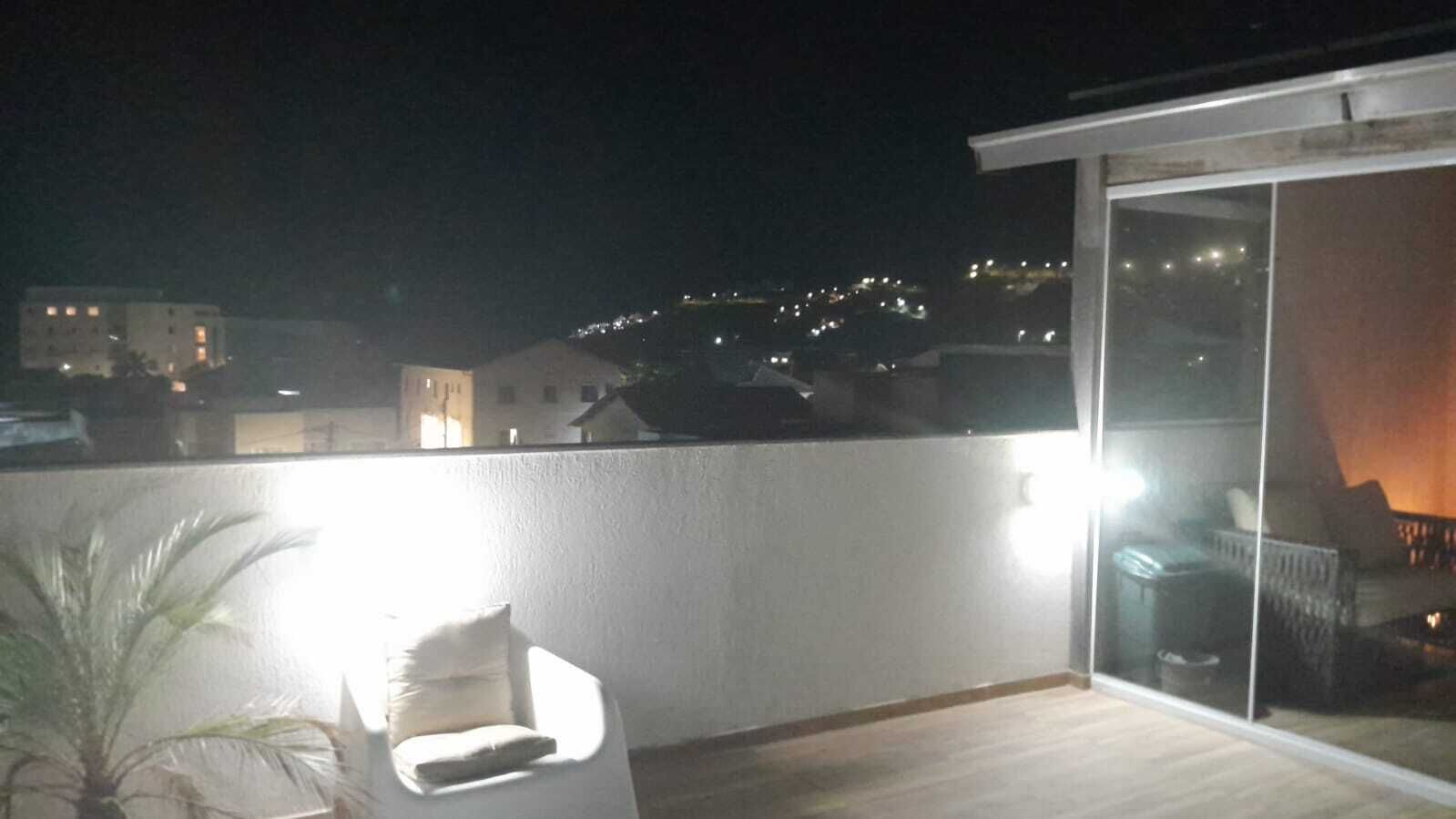 A balcony with a view of a cityscape at night.