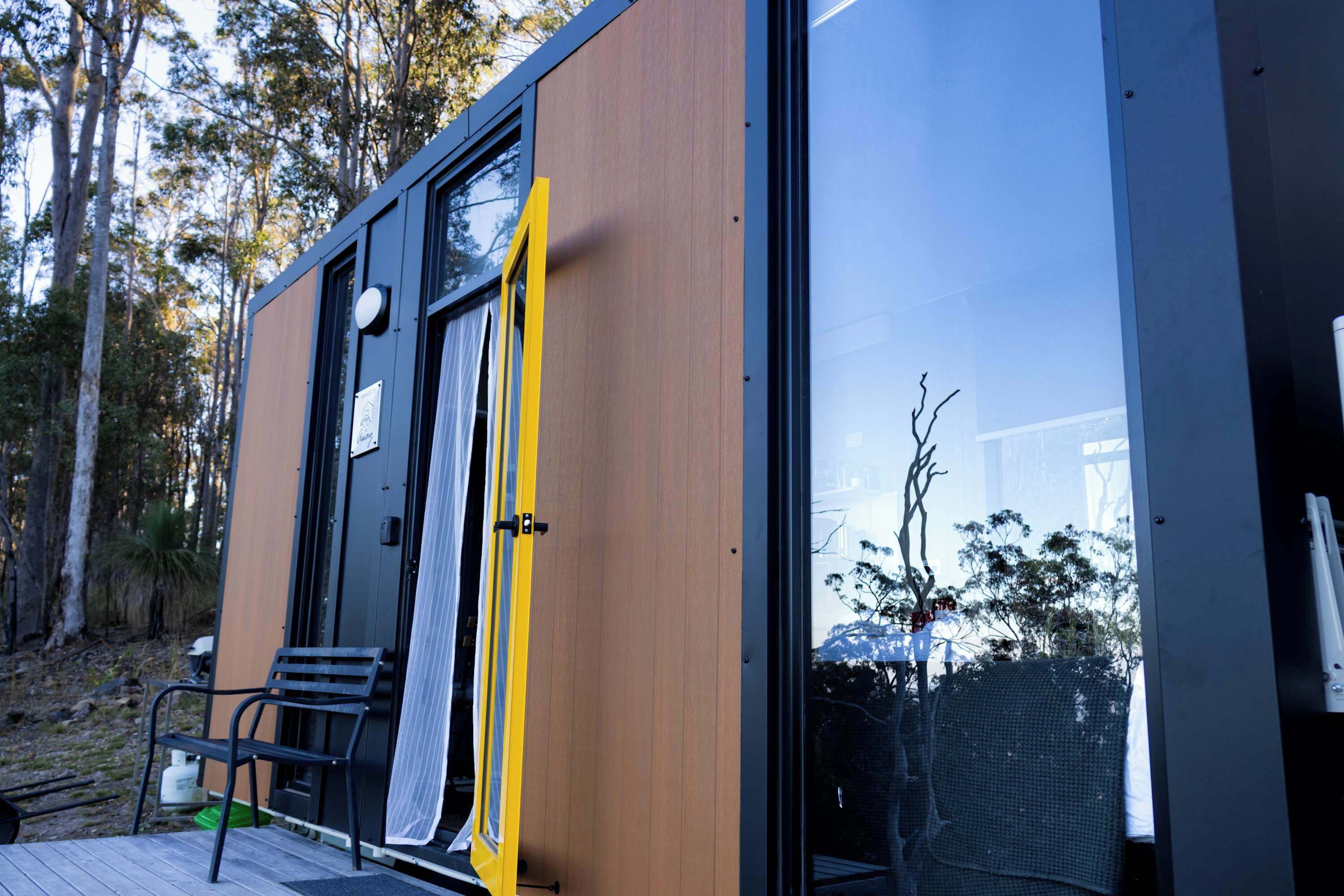 A modern, compact building with a wooden exterior and large glass windows.