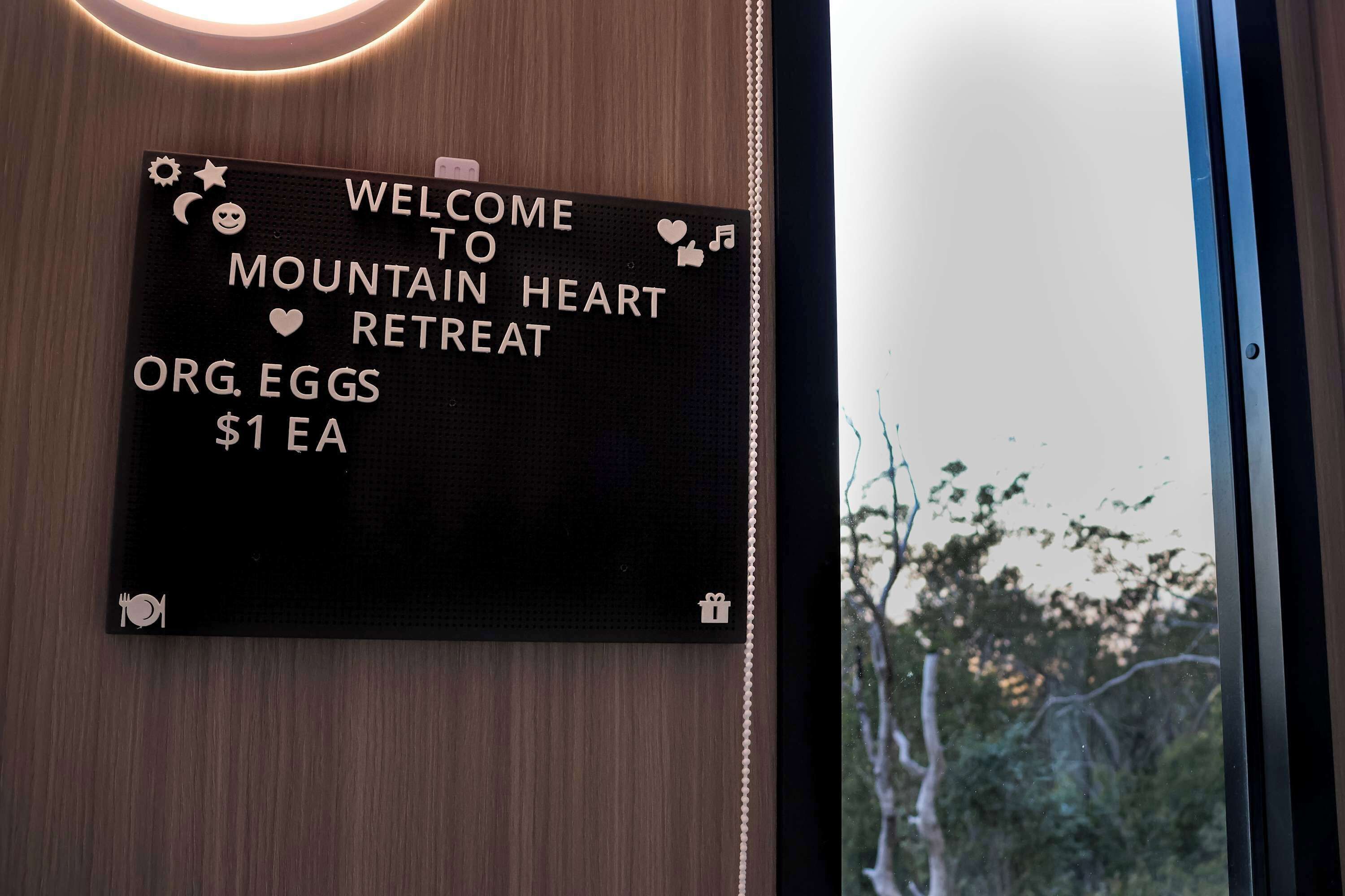 A welcome sign for a mountain retreat with a price of $1 EA for org eggs.