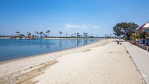 A beach with a clear sky, calm water, and a few palm trees. - Mission Beach 10BR · Steps to Bay & Ocean · Water Views · Firetable (San Diego)