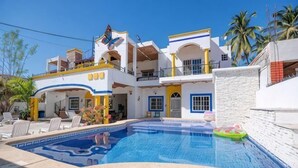 Ein zweistöckiges Gebäude mit Schwimmbad, Außenbereich und Balkon.