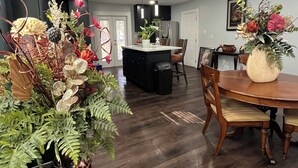Una cocina moderna con armarios negros, una isla central e iluminación colgante.