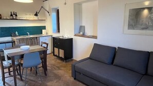 Un espace de vie compact comprenant un coin repas, une kitchenette et un canapé.