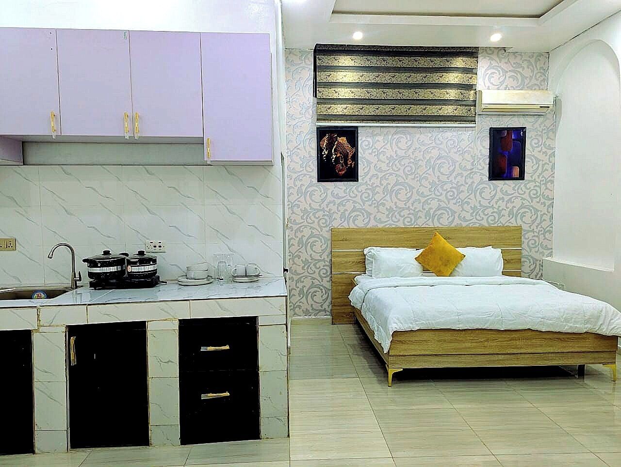 A bedroom with a wooden bed, a nightstand, and a small table with a lamp.