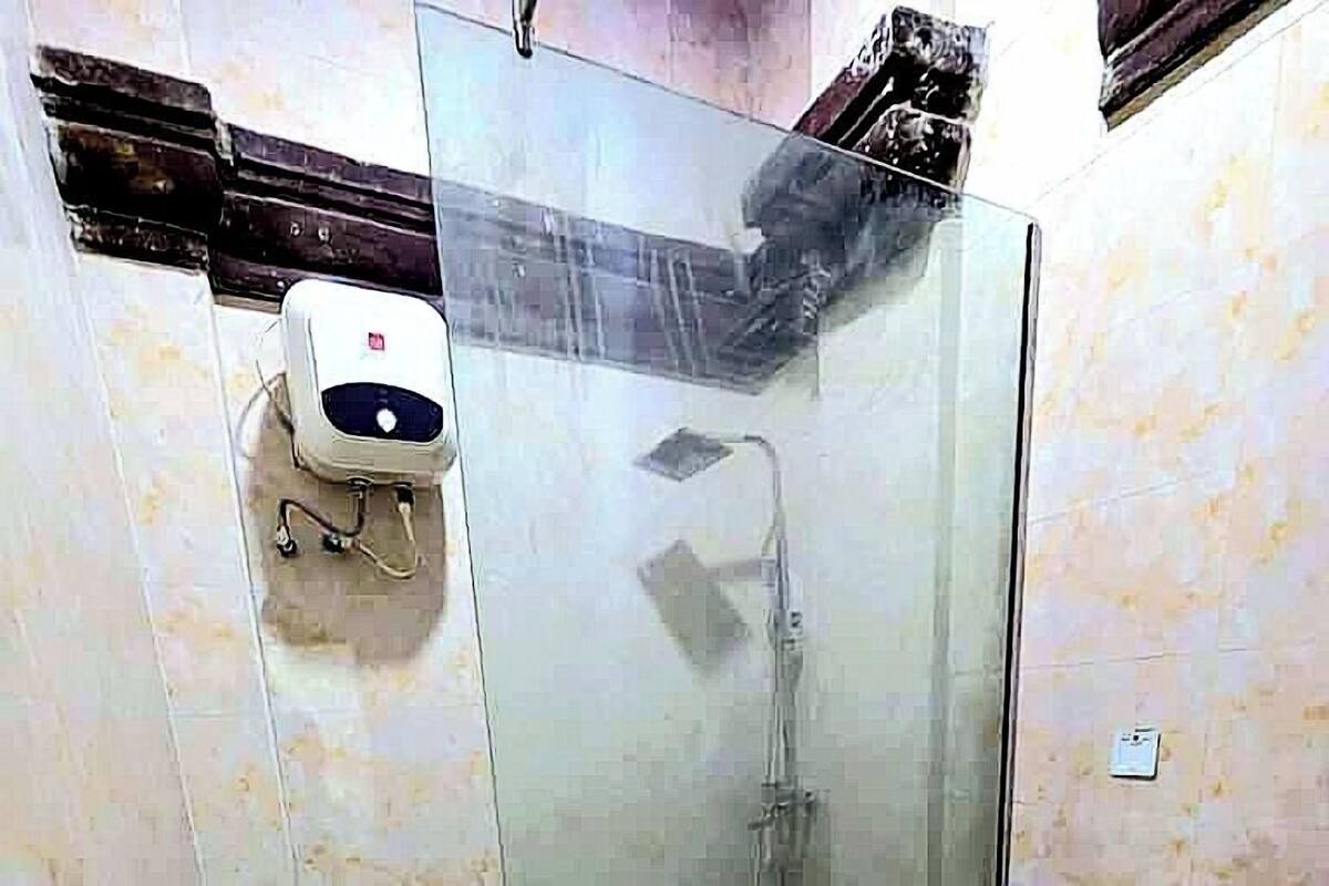 Baño con ducha de vidrio, inodoro y lavamanos.