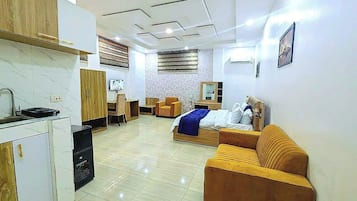 Suite estudio Deluxe | Área de sala de estar | Smart TV de 40 pulgadas con canales por cable