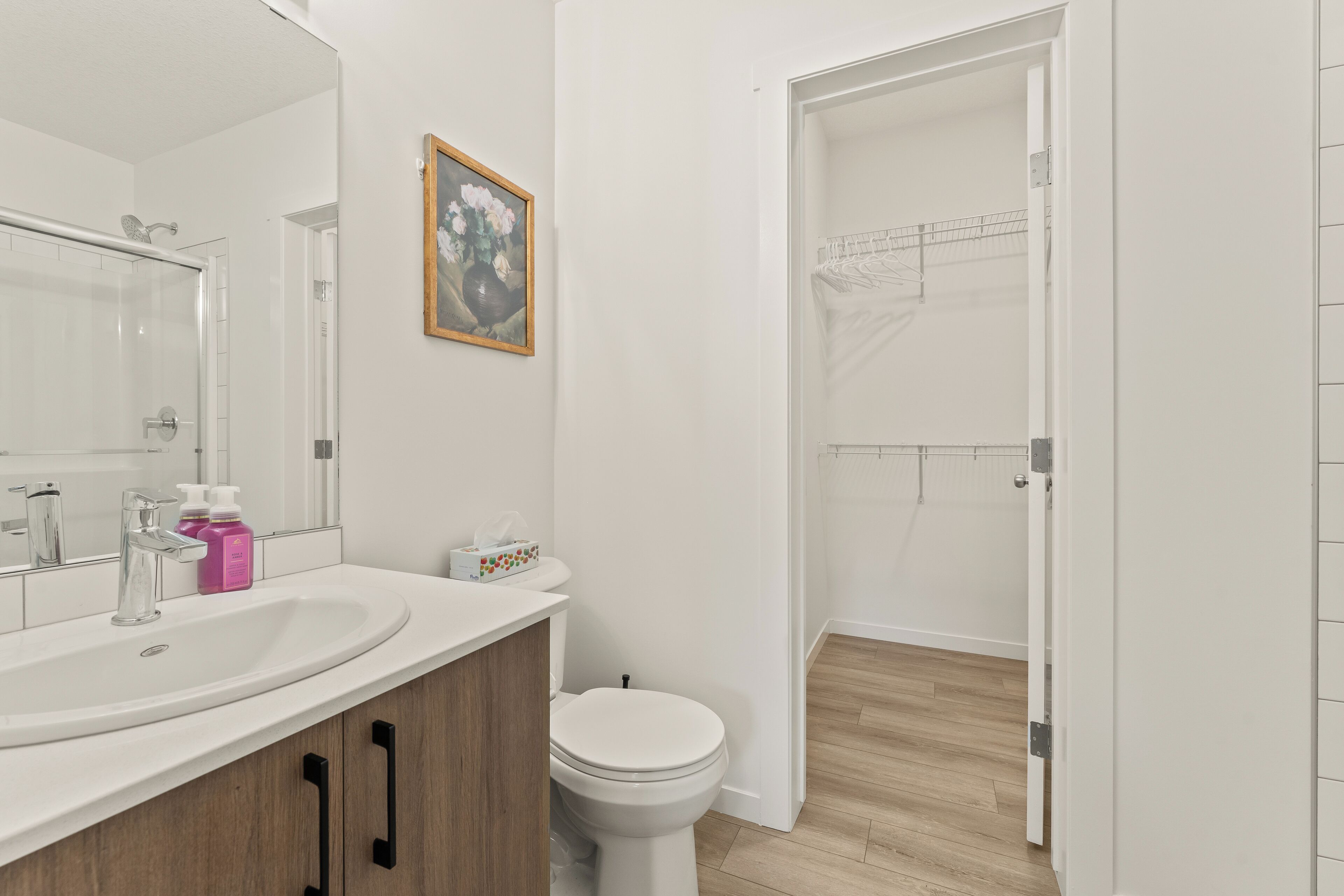 Un bagno moderno con un lavandino bianco, un water e una zona doccia.