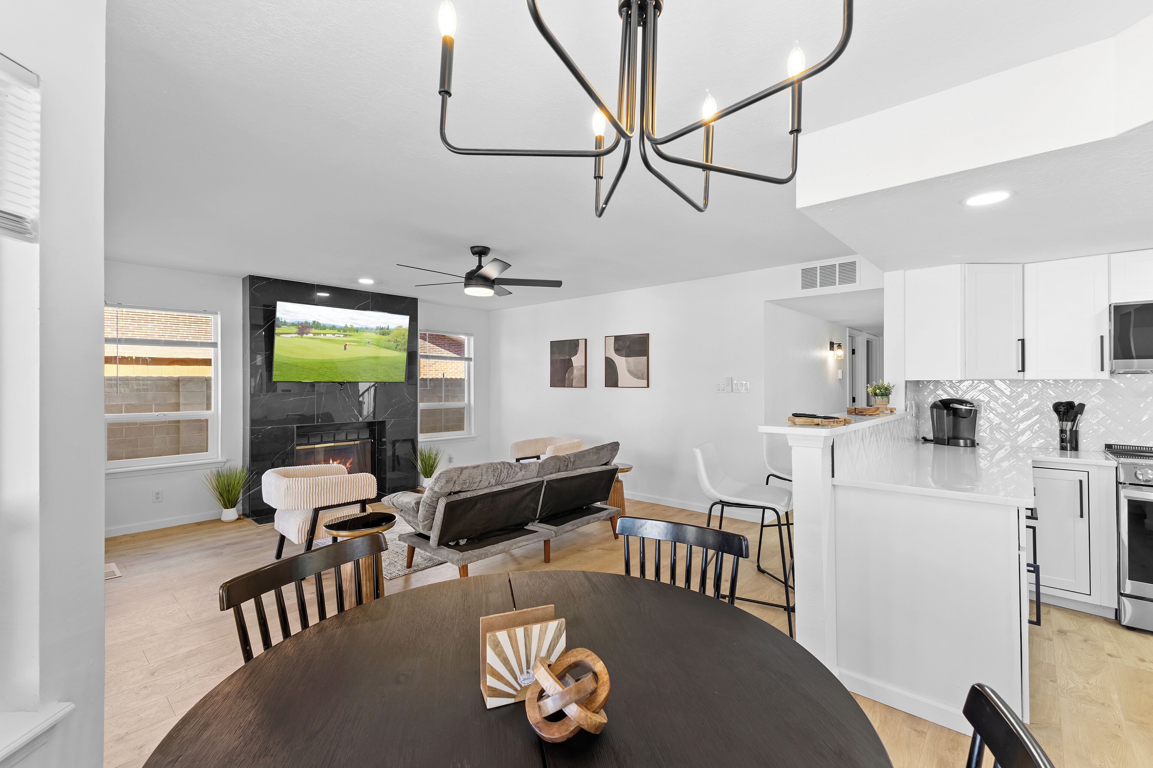 A modern kitchen with white cabinets, a built-in oven, and a microwave.