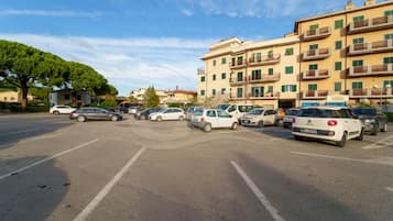 Ein Parkplatz mit mehreren Autos und einem mehrstöckigen Gebäude im Hintergrund.