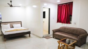 Una habitación con una cama, un sofá y una mesita.