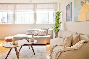 A modern living room with a sofa, a round coffee table, and a potted plant. - Beautiful Curated And Designed Flat In Polanco (Ciudad de México)