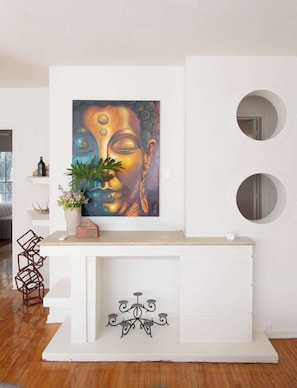 A modern living room with a white fireplace, a Buddha painting, and two round mirrors. - Beautiful Curated And Designed Flat In Polanco (Ciudad de México)