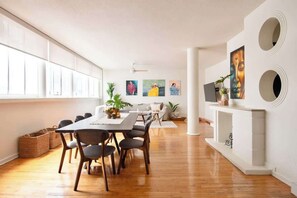 A spacious room with a long dining table, chairs, a fireplace, and artwork on the walls. - Beautiful Curated And Designed Flat In Polanco (Ciudad de México)