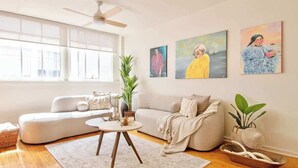 Ein modernes Wohnzimmer mit einer Couch, einem Couchtisch und Kunstwerken an den Wänden.