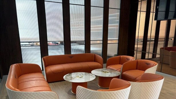A modern lounge area with leather sofas and round tables, large windows with blinds, and a wooden floor. - Hotel Four Point Corner (Pali)