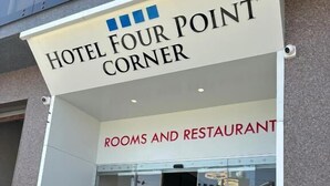 A hotel entrance with a sign reading "HOTEL FOUR POINT CORNER" and "ROOMS AND RESTAURANT" below. - Hotel Four Point Corner (Pali)