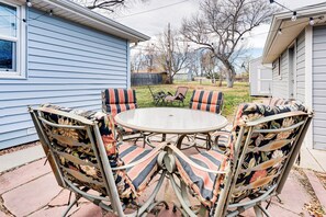 A patio with a round table and four chairs with floral upholstery.
