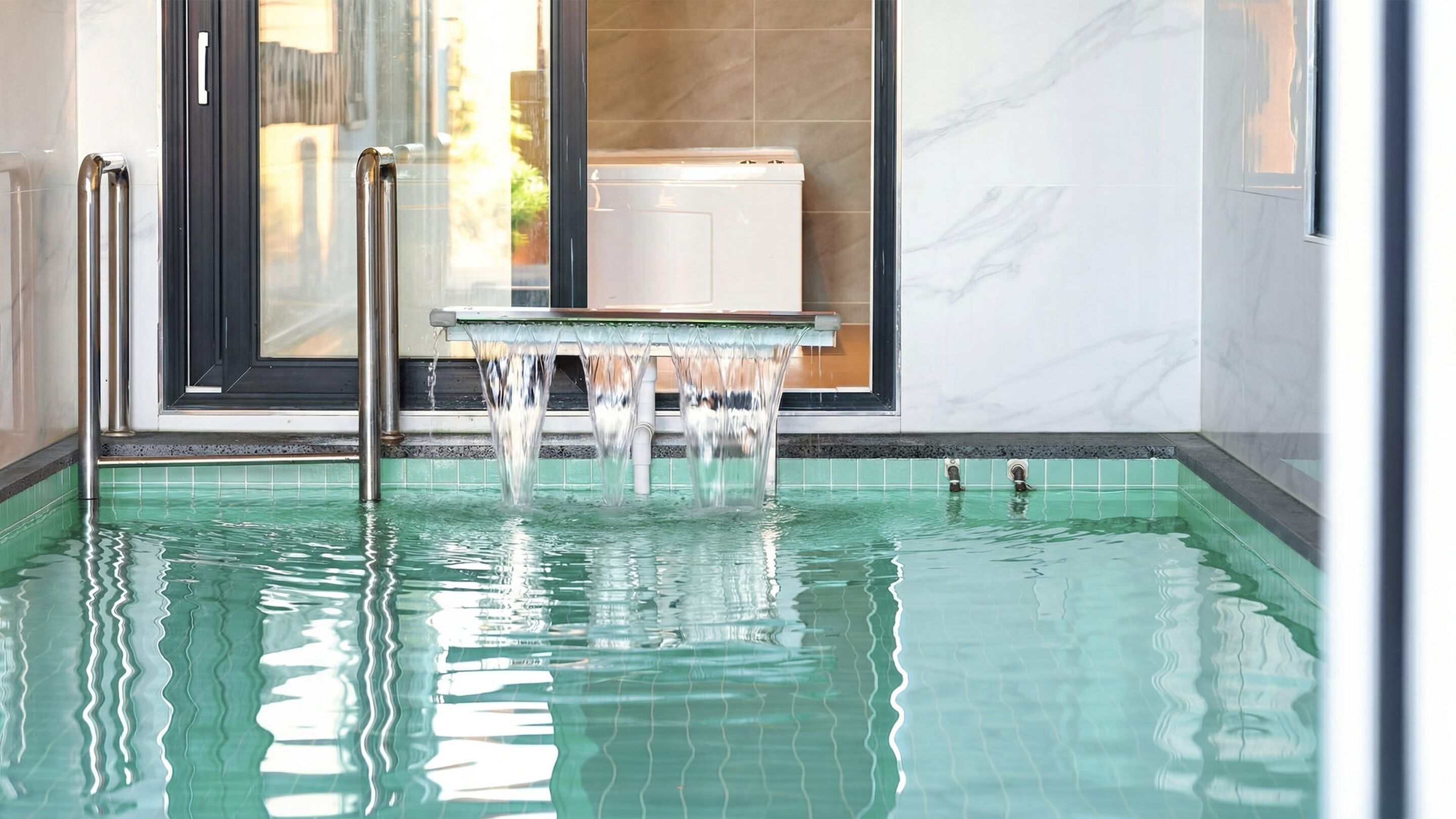 A modern indoor pool with clear water, a glass edge, and a view of the outside through a large window.