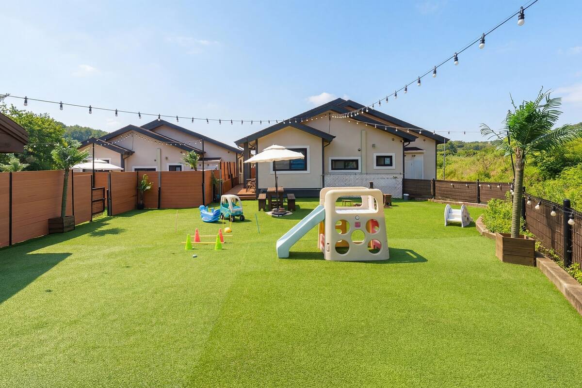 A backyard with artificial grass, a play structure, and a small pool.