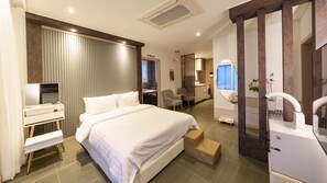 A modern hotel room with a large bed, a desk, a chair, a small table, and a mirror. - Taean Holy Dog Pool Villa (Taean)