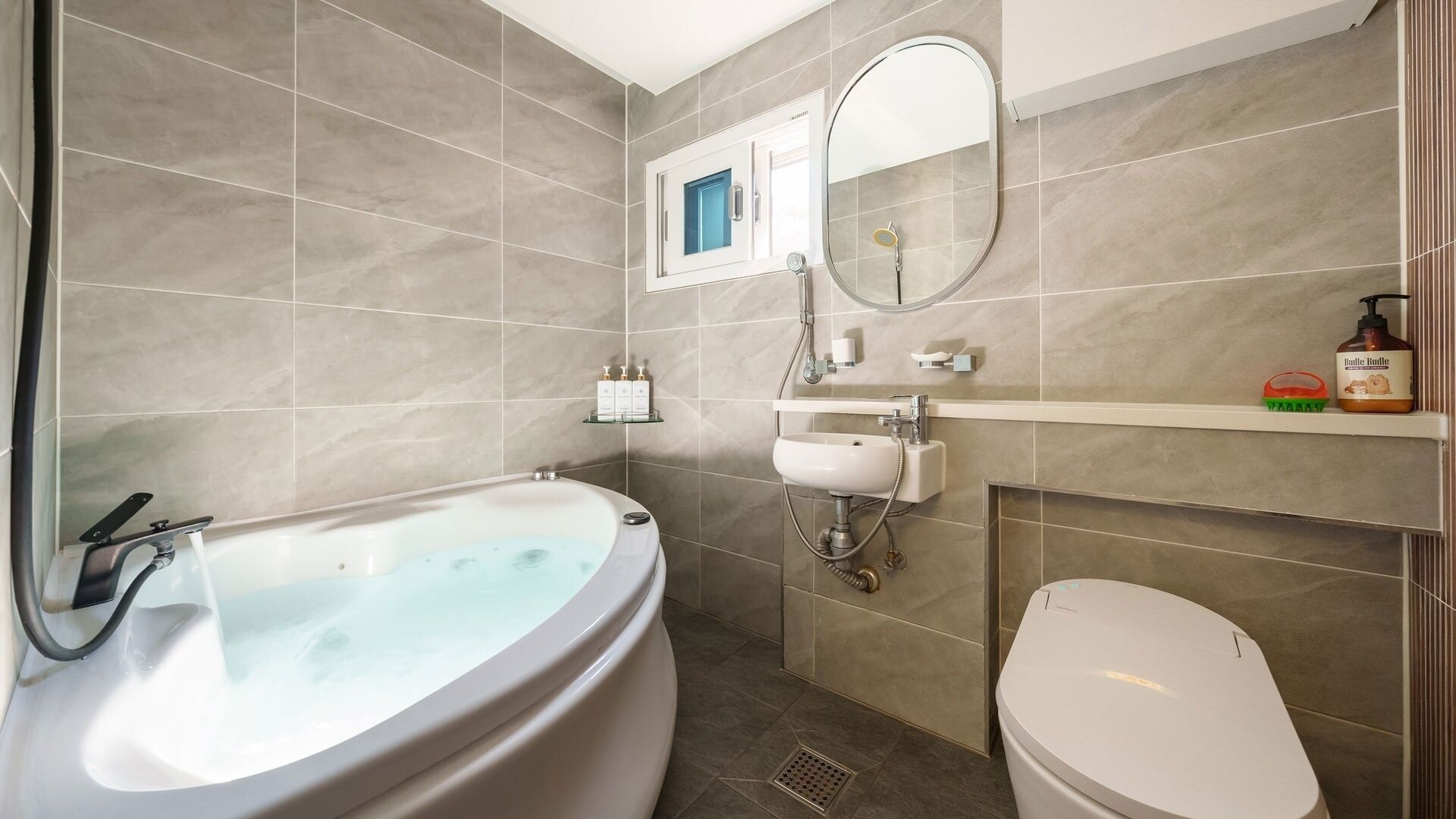 Un baño con bañera, inodoro, lavabo y espejo.