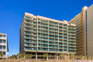A multi-story hotel with balconies, a flat roof, and a clear blue sky. - Oceanfront condo w/private balcony, pool, direct beach access & close to golf (North Myrtle Beach)