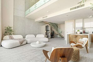 A modern living room with a sofa set, a coffee table, and a dining area with chairs. - Silkhaus Luxury 1BR | Mamsha Saadiyat Sea View (Abu Dhabi)