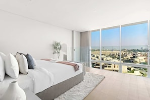 A modern bedroom with a large bed, a view of the city, and a balcony. - Silkhaus Luxury 1BR | Mamsha Saadiyat Sea View (Abu Dhabi)